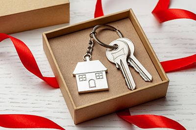 an opened jewerly box with keys to a house inside