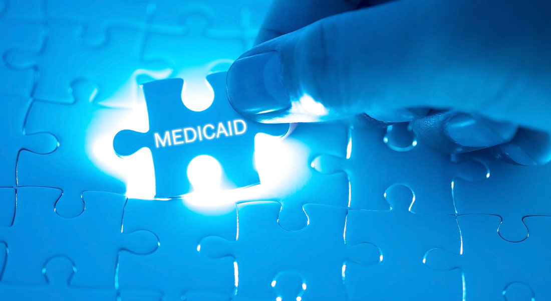 a puzzle being put together which spells MEDICAID