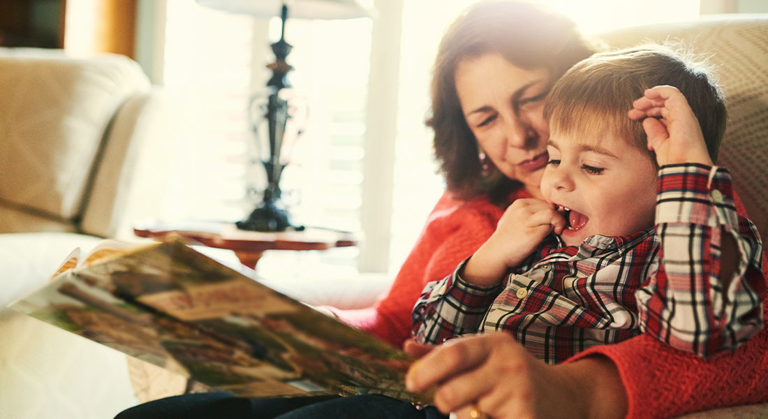a grandmother looking at a book with her grandson