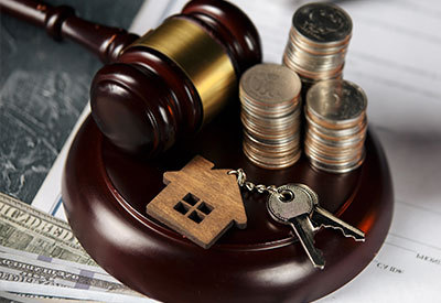 gavel, stack of coins and house keys on a desk