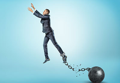 person breaking away from a ball and chain