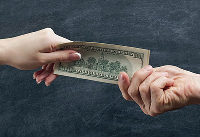 someone handing money to another person