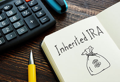 A close-up image of a notebook with 'Inherited IRA' written next to a drawing of a money bag.