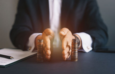 A beneficiary disclaiming a portion of an inheritance by splitting a stack of coins in half.