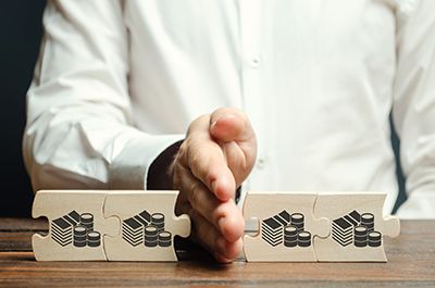 a hand splitting a couple of puzzle pieces