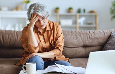 an upset older woman trying to make financial decisions after the death of her spouse