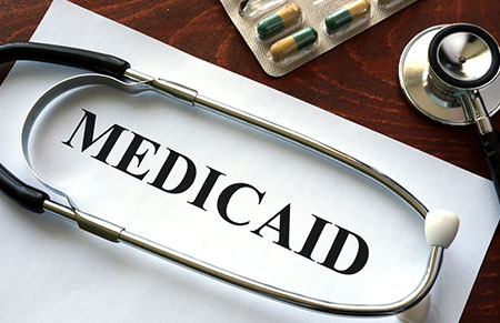A stethoscope on a piece of paper that says Medicaid in all caps.