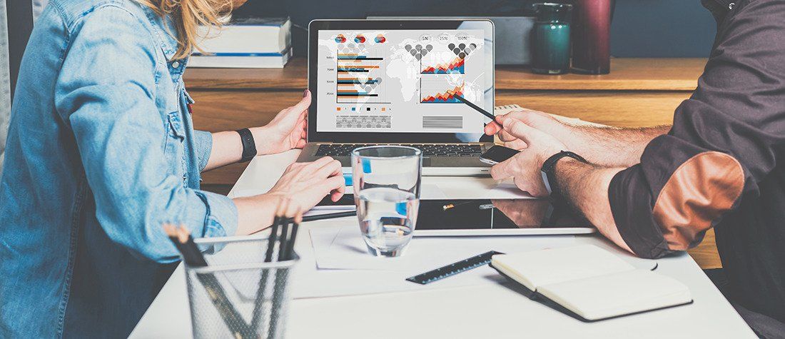 Business meeting going over data on a laptop