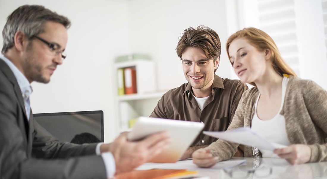 Professional going over documents with a couple in an office