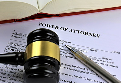 power of attorney document with a pen and gavel on top