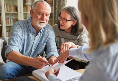 An older couple discussing documents with a person