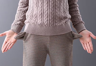 A person with empty pockets, indicating financial exploitation and the aftermath of estate planning fraud.