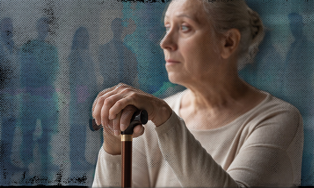 A contemplative older person in a cream sweater gazes into the distance while resting their hands on a walking cane