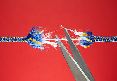 pair of scissors cutting a rope