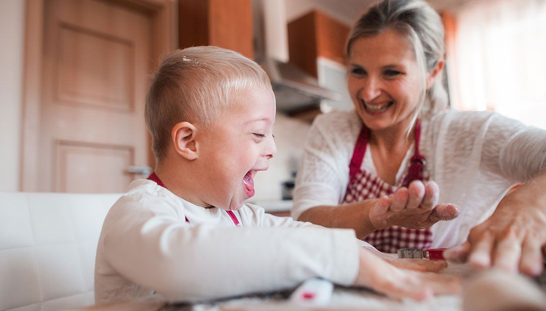 a caregiver laughing with a child with special needs