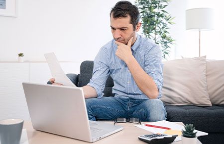 a man looking at his computer with a look of concern
