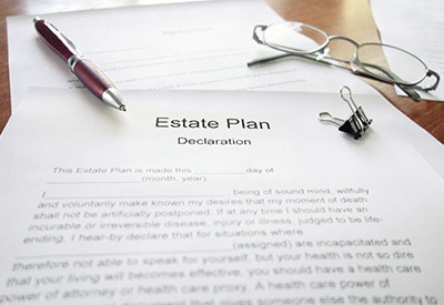 estate planning declaration paper with a pen and glass sat on top