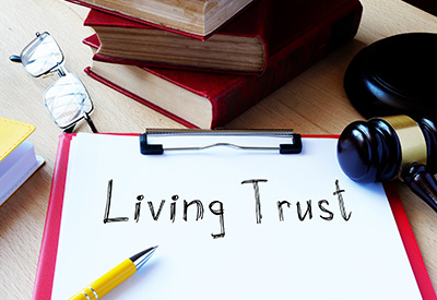 A clipboard with 'Living Trust' written on it, surrounded by legal books and a gavel
