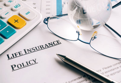 Life insurance policy documents alongside glasses and a calculator