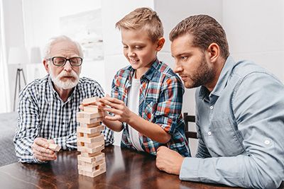 a grandpa dad and son playing Jenga