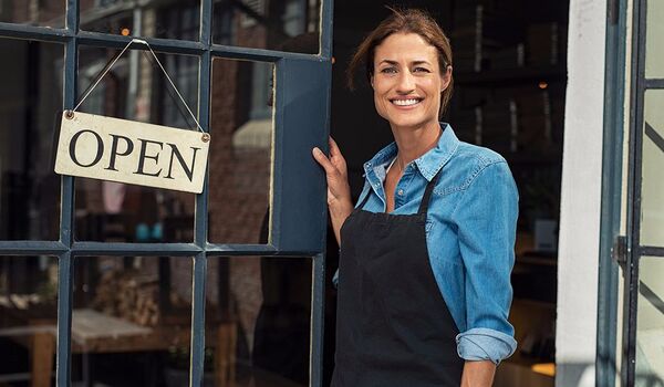 a business owner holding the door open to their business