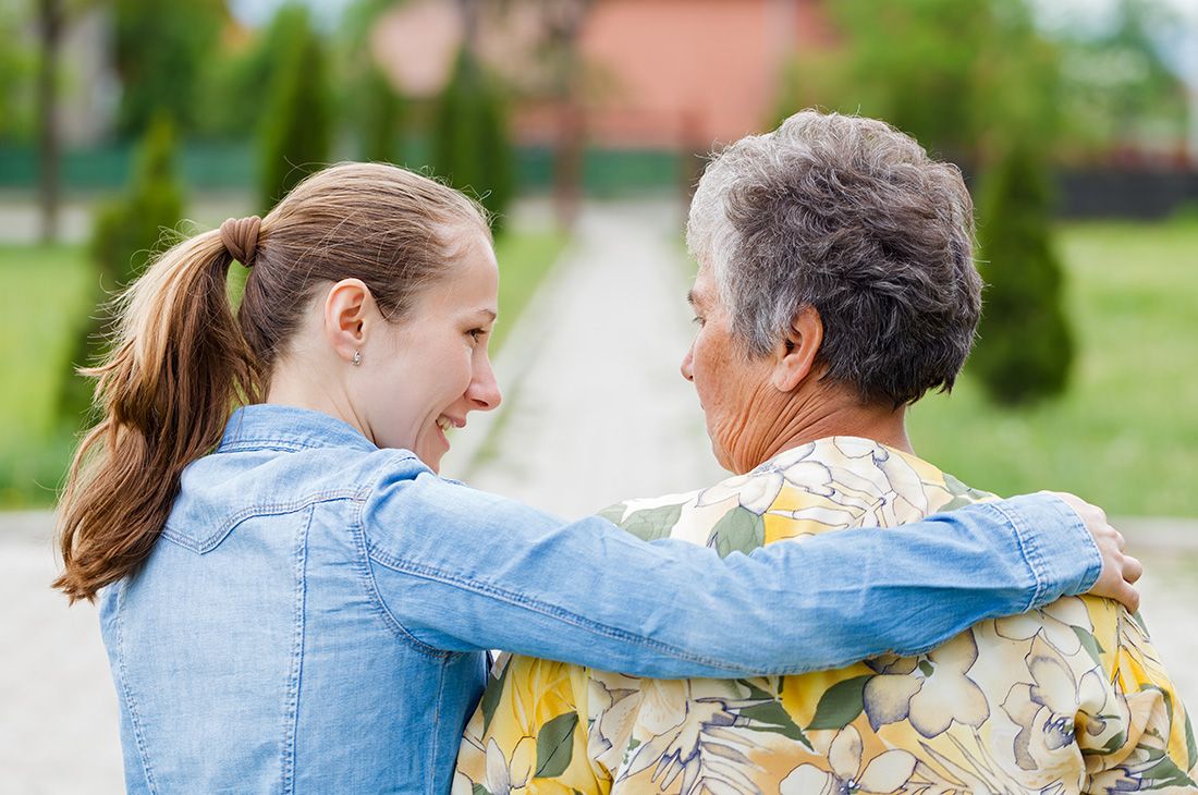 an adult child hugging and talking with mother
