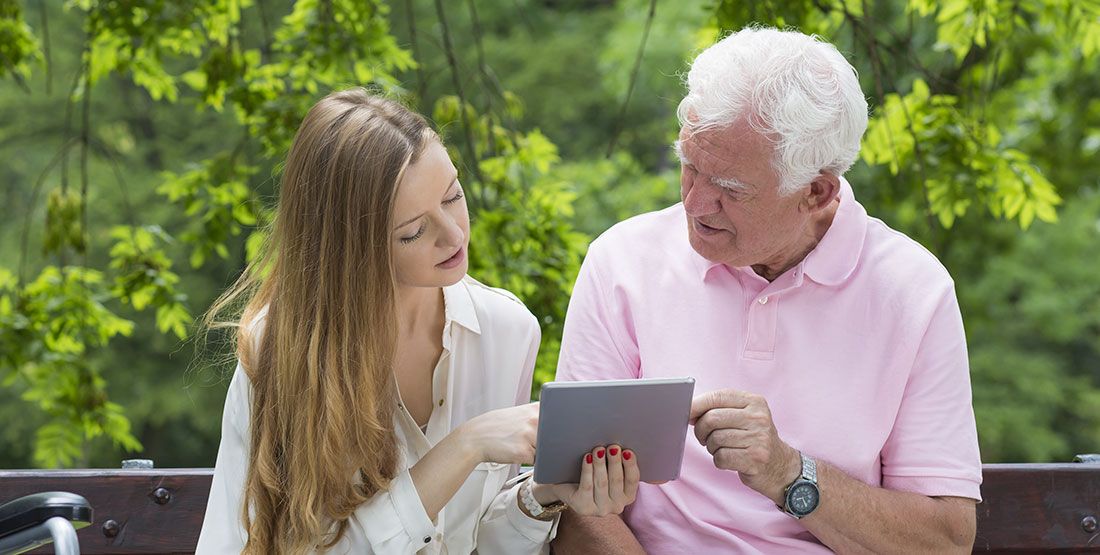 a younger woman going over trustee documents with an older man