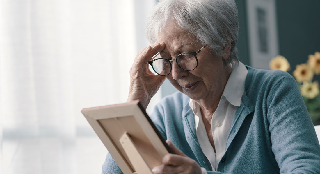 A woman looking stressed while looking at a photograph.