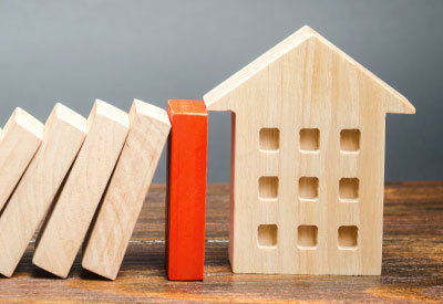 Toy wood blocks leaning against wooden block house