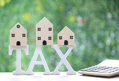 wooden letters spelling out Tax with a wooden house on top of each letter