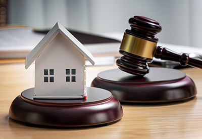 a gavel on desk with model home