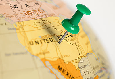 a pin stuck on a location of a globe