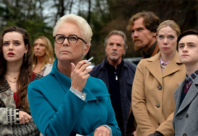 woman standing looking focused with family behind her