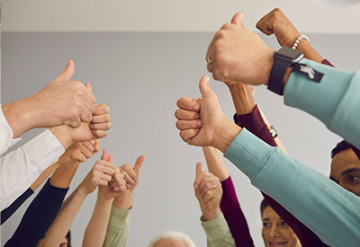 group of hands holding thumbs up