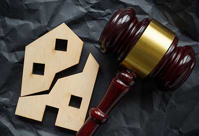 A judge's gavel beside a broken house symbolizing estate planning and disinheritance issues.