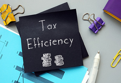 A chalkboard displays "Tax Efficiency" alongside office supplies, emphasizing strategies for optimizing tax outcomes in financial planning