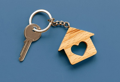 A house-shaped keychain with a heart cutout, symbolizing the security of a familys primary residence and protection from creditors.