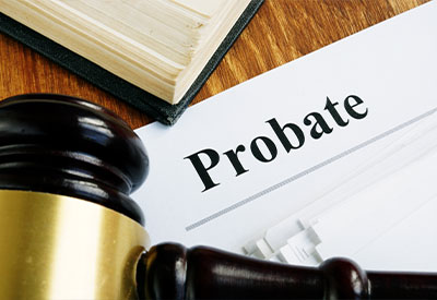 Close-up of a wooden gavel next to a document titled 'Probate' on a wooden surface
