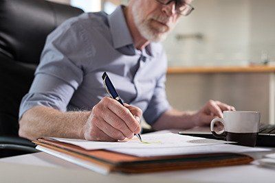 Estate Plan - Senior man at his desk working on his estate plan