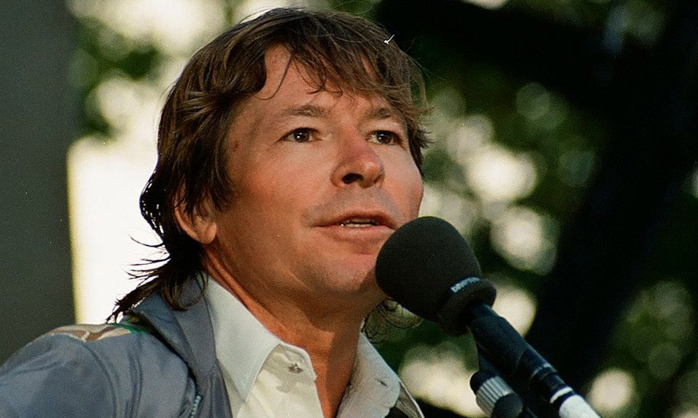 John Denver singing into microphone