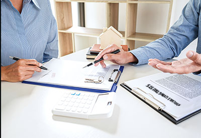 A discussion between two individuals reviewing legal documents related to property transfer, potentially involving a life estate deed or a revocable living trust.