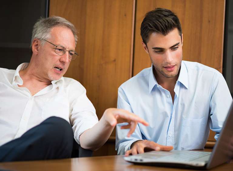 Two men working on a laptop