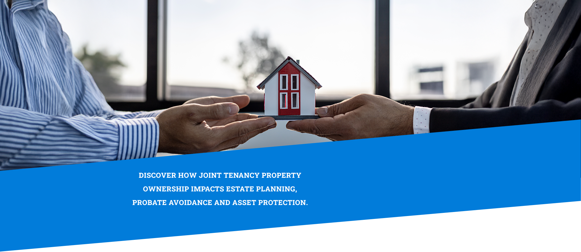 two pair of hands holding a model home over paper work