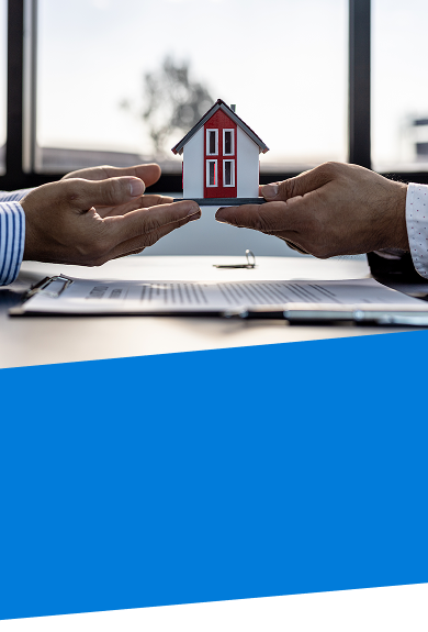 two pair of hands holding a model home over paper work