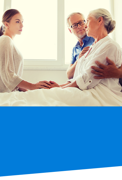 Lady in a care facility bed with husband and daughter by her side representing incapacity planning and guardianship