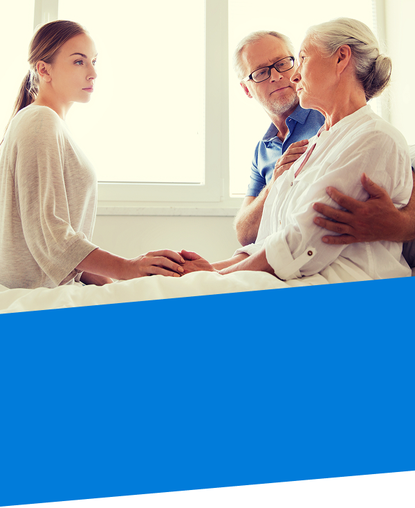 Lady in a care facility bed with husband and daughter by her side representing incapacity planning and guardianship