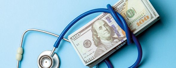 A stethoscope wrapped around 100 dollar bills